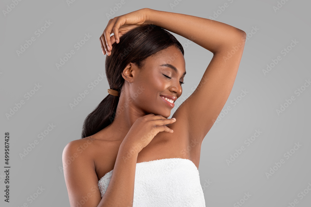 Fototapeta premium Smiling millennial african american woman with perfect soft skin enjoying beauty and results of routine procedures