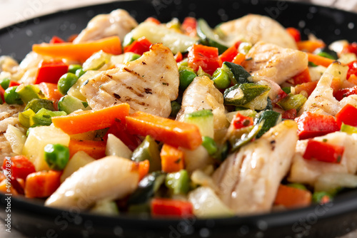 Chicken stir fry and vegetables on wooden table	