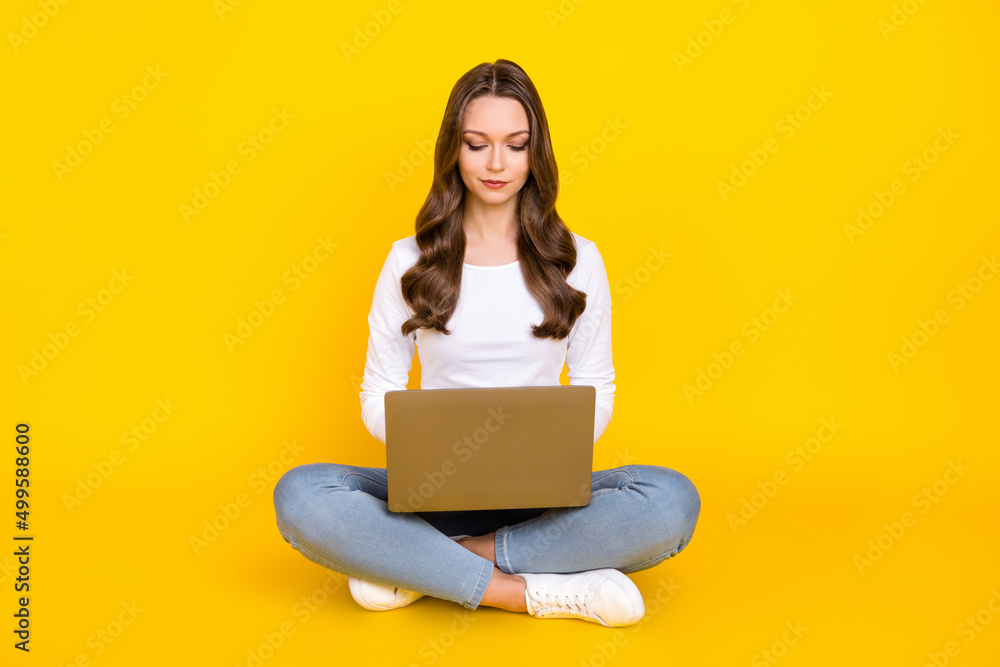 Naklejka premium Photo of cute pretty lady dressed white shirt sitting legs crossed typing modern device isolated yellow color background