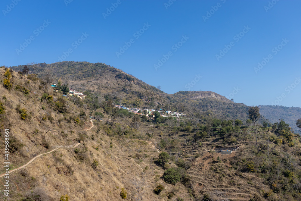 small village at mountain foothills with blue sky at morning