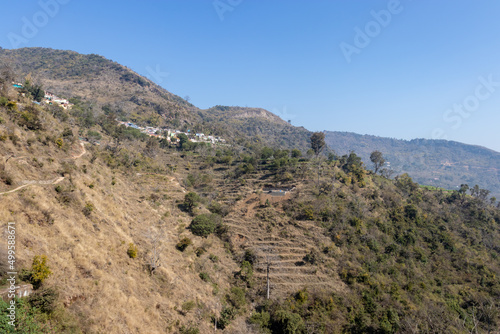 small village at mountain foothills with blue sky at morning