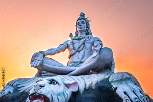 Wallpaper Mural hindu god lord shiva statue in meditation posture with dramatic sky at evening f