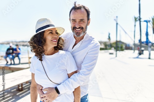 Middle age hispanic couple smiling happy and hugging at the promenade. © Krakenimages.com