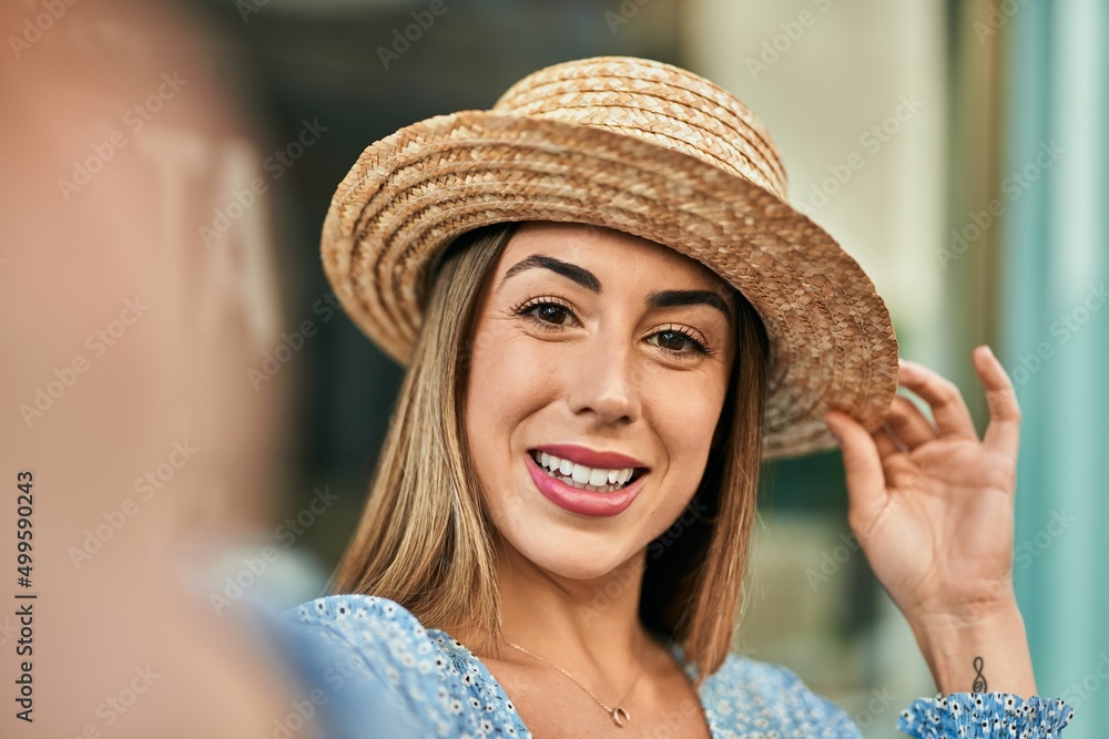 Young hispanic woman wearing miling happy  making selfie by the camera at the city.