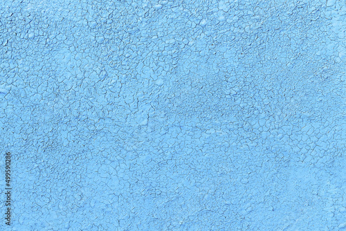 Weathered blue painted background with cracks, flat lay. Wall surface with ripped paint texture.