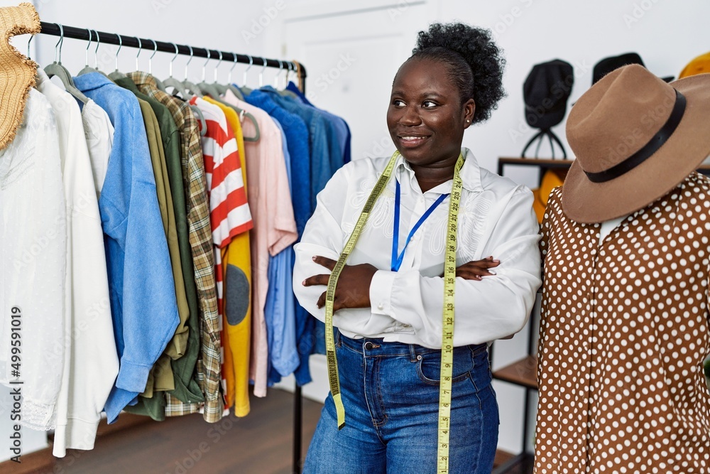 Young african american woman shopkeeper standing with arms crossed gesture at clothing store
