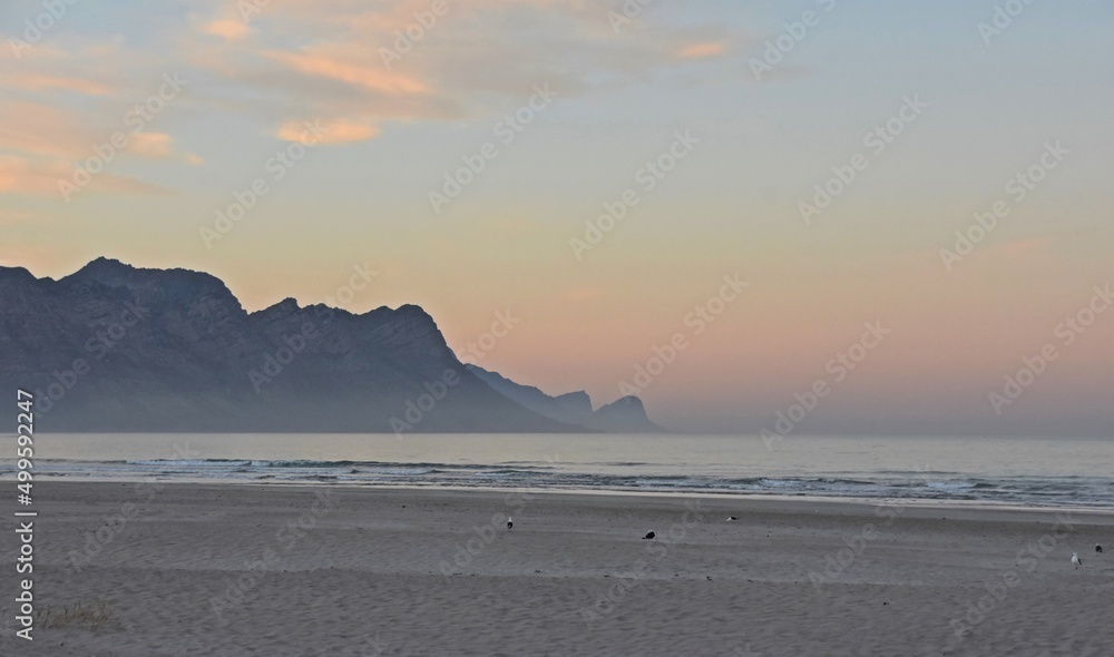 Landscape with a beautiful sunrise over the beach in Strand and the Overberg mountains Landscape with a beautiful sunrise over the beach in Strand and the Overberg mountains