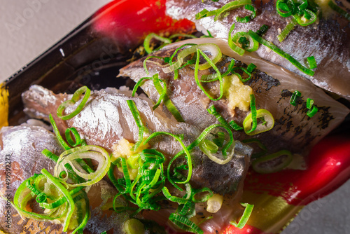 The closeup of Japanese Horse Mackerel Sushi (Aji Sushi) with cut green onions and grated ginger packed in a plastic food container. Aji is the one of popular Sushi-neta in Japanese Edomae style Sushi photo