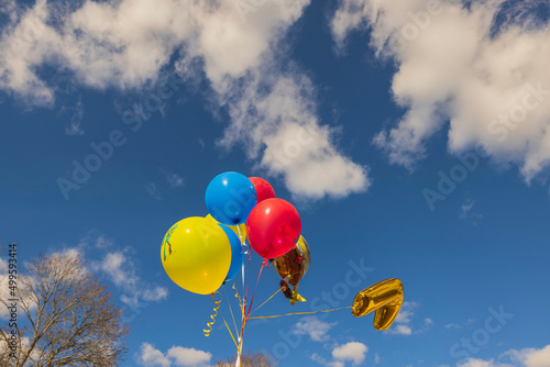 Beautiful view of festive balloons for child developing in  wind against blue sky with white clouds. Sweden.