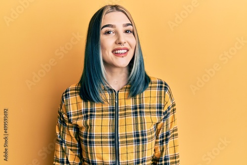 Young modern girl wearing casual yellow shirt with a happy and cool smile on face. lucky person. © Krakenimages.com