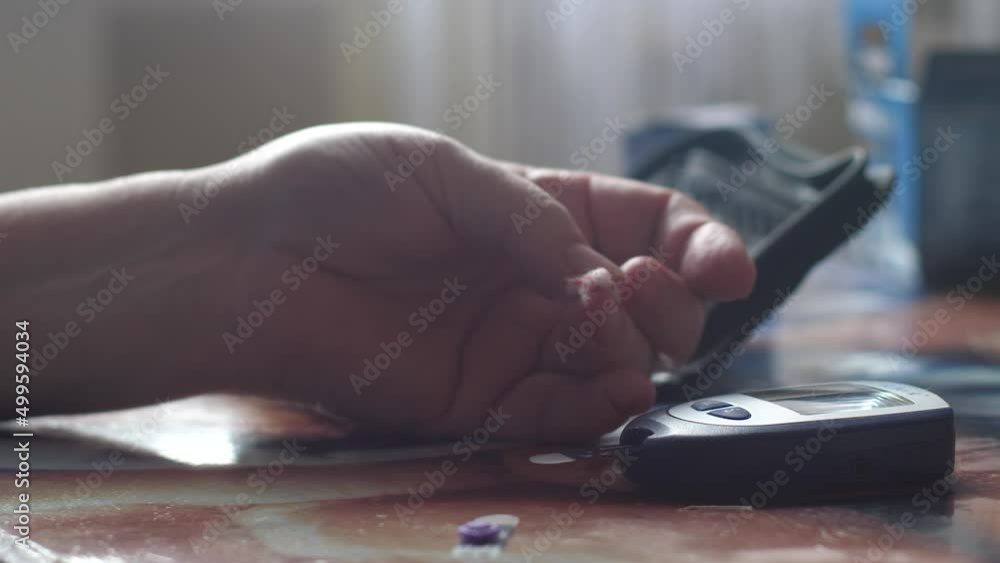 A woman checks her blood glucose levels with a portable glucometer at home. Selective focus. Treatment and maintenance of health in diabetes mellitus. Selective focus A woman checks her blood glucose levels with a portable glucometer at home. Selective focus. Treatment and maintenance of health in diabetes mellitus. Selective focus