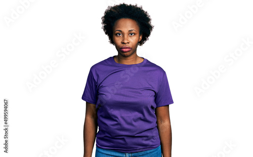 African american woman with afro hair wearing casual purple t shirt relaxed with serious expression on face. simple and natural looking at the camera.