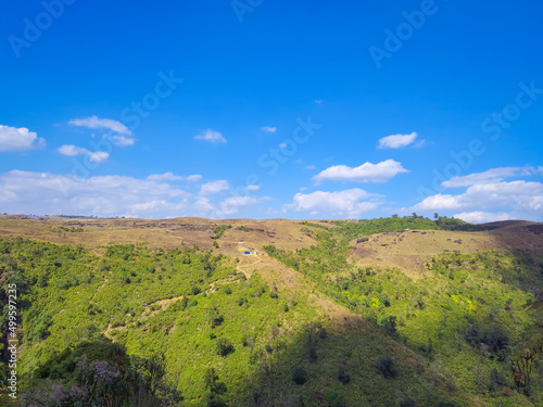 green grass mountain with bright blue sky at morning