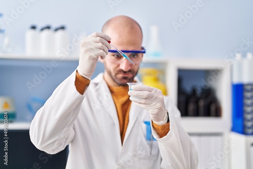 Young man scientist measuring liquid at laboratory