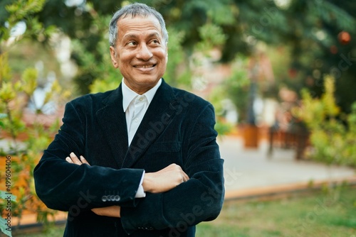 Middle age southeast asian man smiling confident with crossed arms by the park