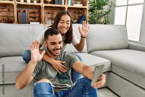 Young latin couple smiling happy having video call using smartphone at home.
