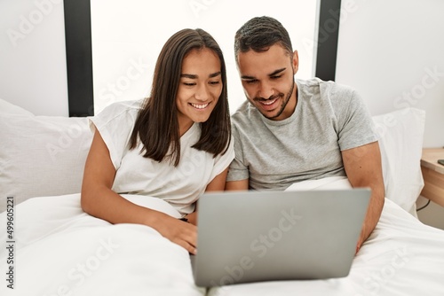 Young latin couple smiling happy using laptop at bedroom