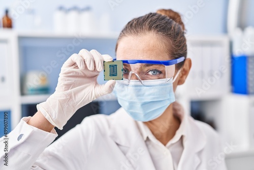 Young woman scientist holding cpu processor at laboratory