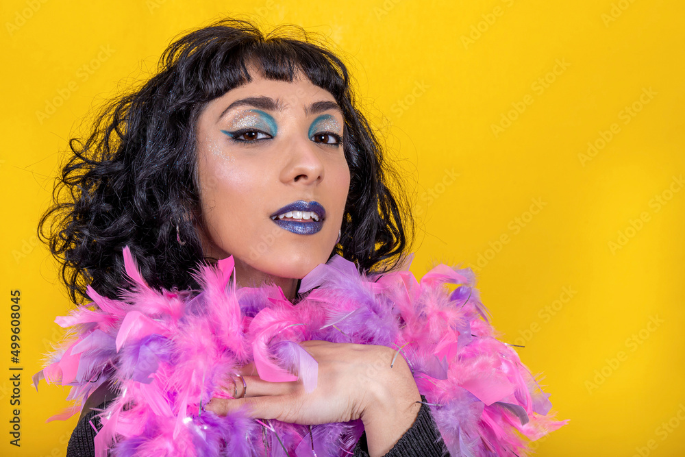 The young woman is wearing a scarf with pink and purple feathers. Beautiful woman has fun at the party. Party concept. The young woman is wearing a scarf with pink and purple feathers. Beautiful woman has fun at the party. Party concept.