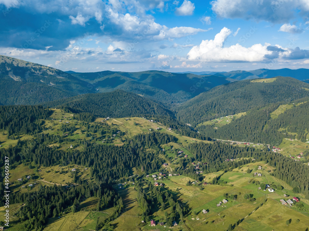 Obraz premium Green mountains of Ukrainian Carpathians in summer. Sunny day, rare clouds. Aerial drone view.