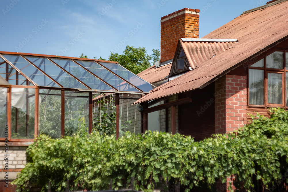 Ukraine. Slavutych town before war. Peaseful romantic village. Summer heat. Noon. Brick house with chimney. Greenhouse.