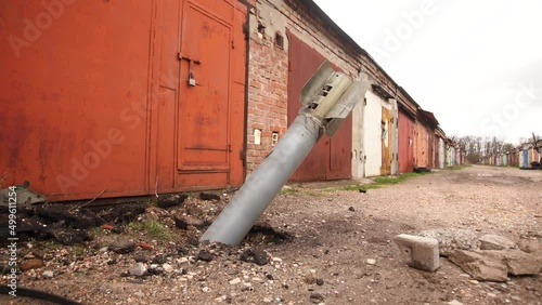 Wallpaper Mural Close-up view 4k video footage of real unexploded military missile, torpedo or shell stuck in ground near doors of garages outdoors. Moments of dreadful war of Russia against Ukraine in 2022 Torontodigital.ca