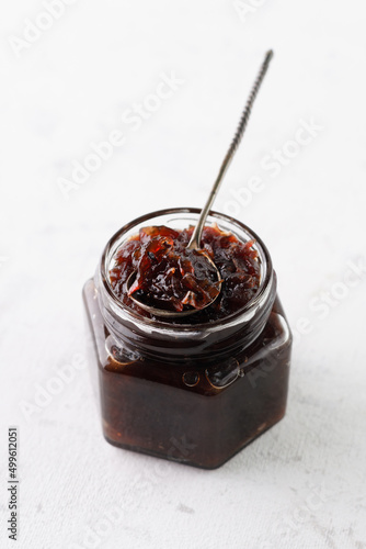 onion marmalade (Onion confiture). onion confit in a glass jar on a white background.