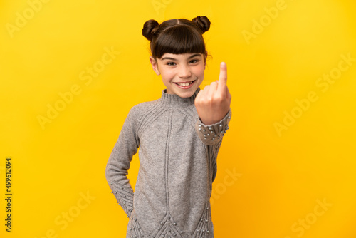 Little caucasian girl isolated on yellow background doing coming gesture