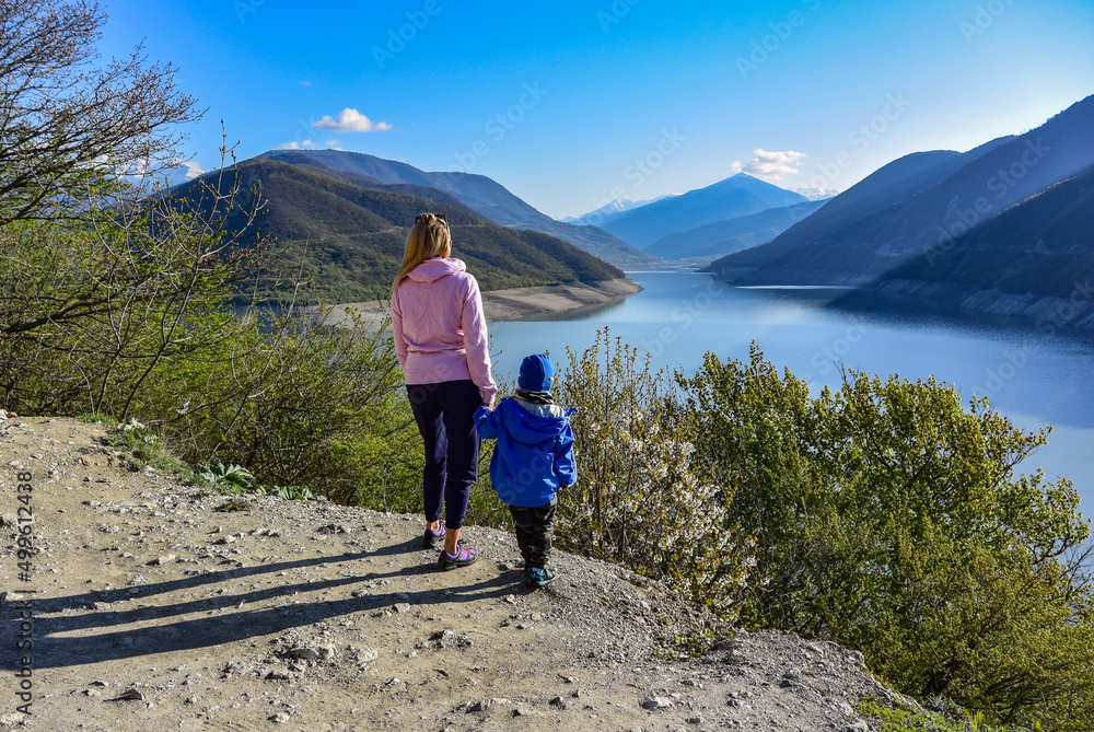 A young girl and a little boy on the background of the landscape of the Zhinvali reservoir. Georgia 2019.