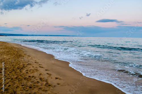 Fototapeta Naklejka Na Ścianę i Meble -  Summer evening at the seashore. View of the soft sea wave on the sandy beach.