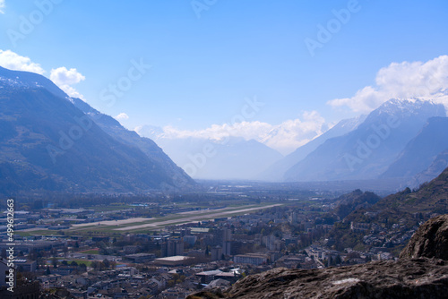 Panoramic view from a hill over City of Sion with airfield, alley and Swiss Alps in the background on a sunny spring day. Photo taken April 4th, 2022, Sion, Switzerland.