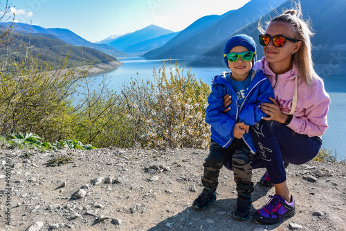 A young girl and a little boy on the background of the landscape of the Zhinvali reservoir. Georgia 2019. photo