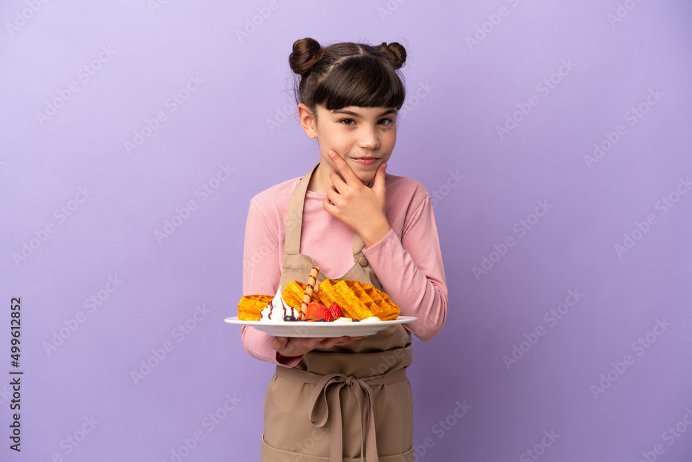 Little caucasian girl holding waffles isolated on purple background thinking Little caucasian girl holding waffles isolated on purple background thinking