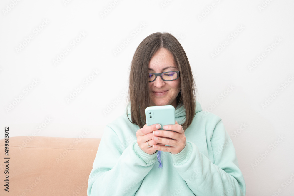 Portrait of a smiling casual woman holding smartphone over white background Portrait of a smiling casual woman holding smartphone over white background