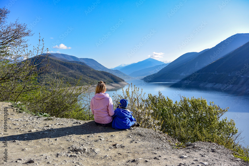 A young girl and a little boy on the background of the landscape of the Zhinvali reservoir. Georgia 2019.