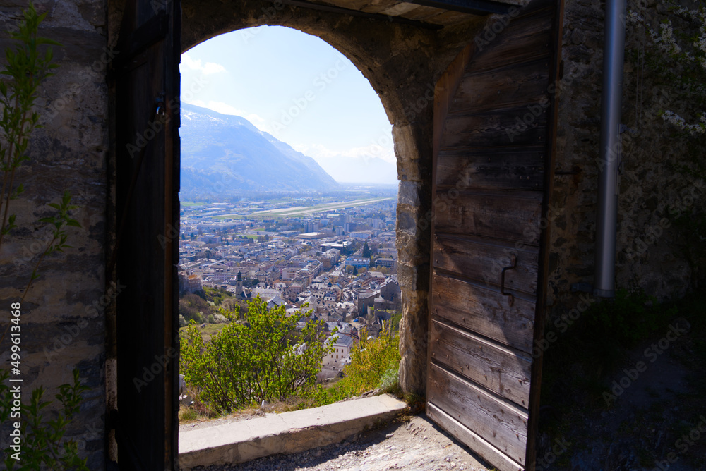 Beautiful view through stone arch of ruins of medieval Tourbillon Castle on a hill at City of Sion on a sunny spring day. Photo taken April 4th, 2022, Sion, Switzerland.