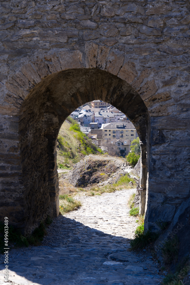 Beautiful view through stone arch of ruins of medieval Tourbillon Castle on a hill at City of Sion on a sunny spring day. Photo taken April 4th, 2022, Sion, Switzerland.