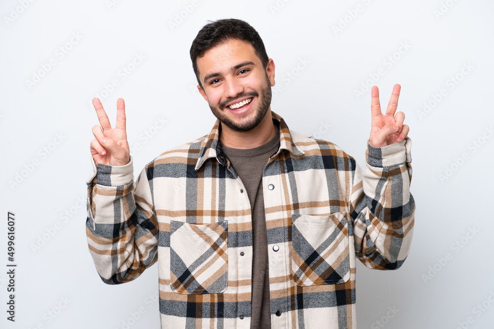 Young Brazilian man isolated on white background showing victory sign with both hands Young Brazilian man isolated on white background showing victory sign with both hands