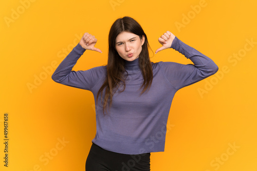 Young Ukrainian girl isolated on yellow background proud and self-satisfied