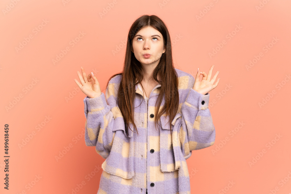Young Ukrainian girl isolated on pink background in zen pose Young Ukrainian girl isolated on pink background in zen pose
