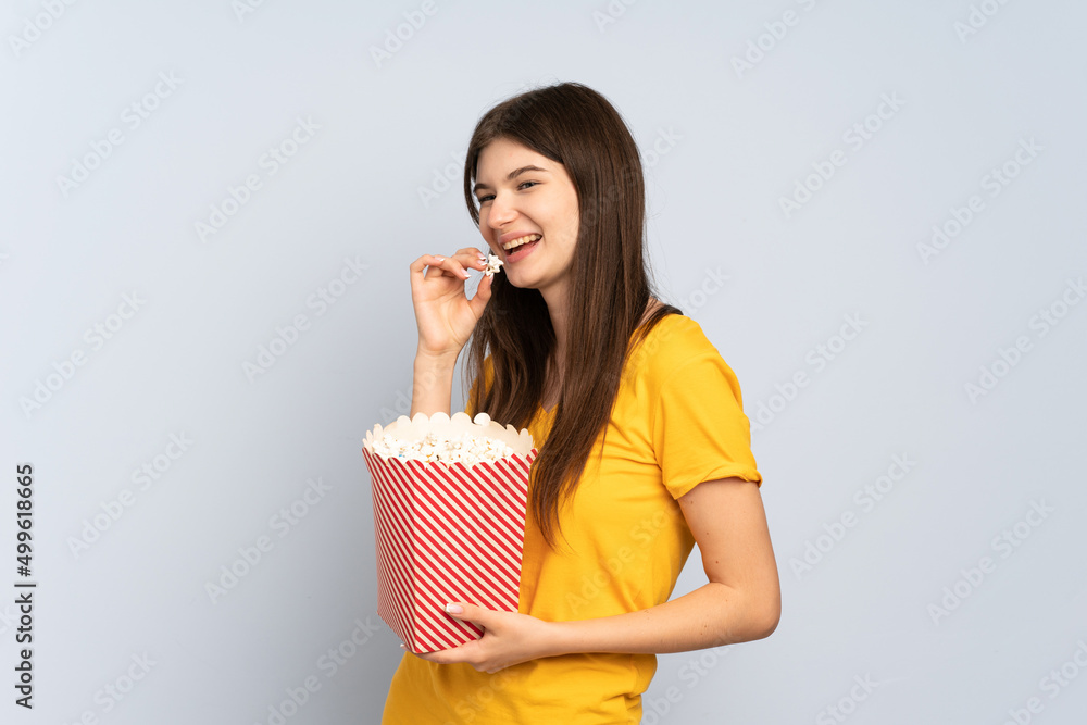 Young Ukrainian girl isolated on white background holding a big bucket of popcorns Young Ukrainian girl isolated on white background holding a big bucket of popcorns