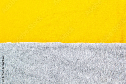 Grey and yellow knitted fabric cotton textured background. Closeup with copy space for your design