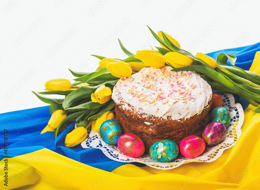 Ukrainian symbols. Easter holiday. Easter cake, colored eggs and tulips on the background of the Ukrainian flag
