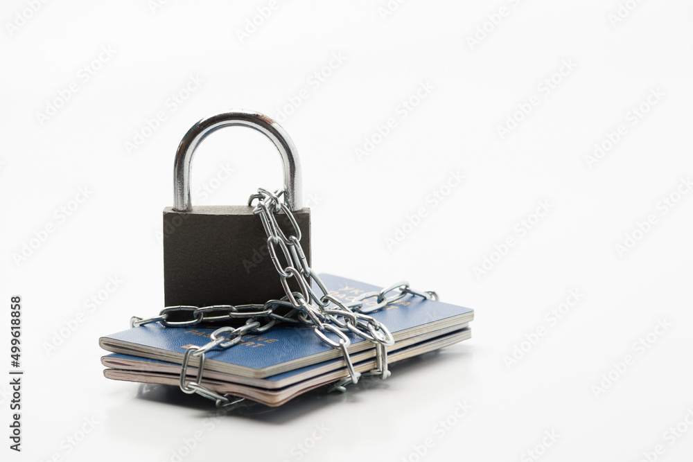 several passports of the citizen of Ukraine with an emblem on a wrapper locked with a chain and padlock lying on a white background several passports of the citizen of Ukraine with an emblem on a wrapper locked with a chain and padlock lying on a white background