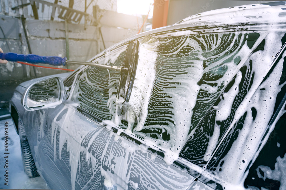 Car wash with a scrub brush, car wash, a lot of active foam on the car