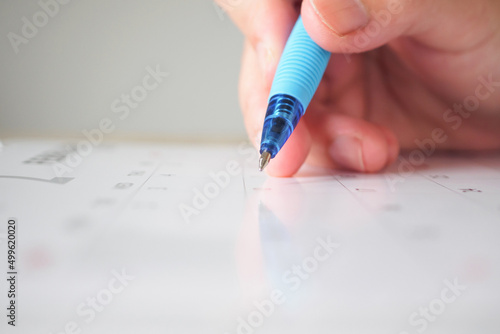 Woman hand with pen writing on calendar date business planning appointment meeting concept