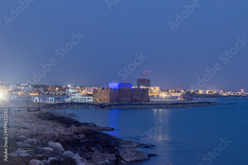 Fototapeta Naklejka Na Ścianę i Meble -  Evening view with Paphos Castle with reflection on the water. Dusk in Paphos, Cyprus.
