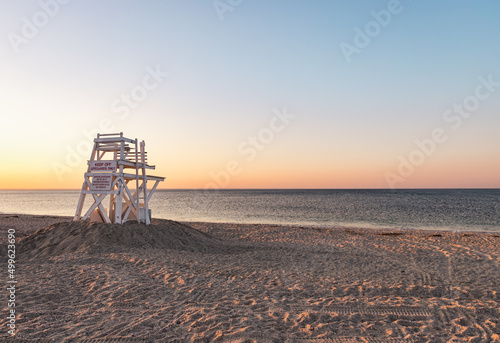 Lifeguard stand on an empty beach during sunset  © Erica