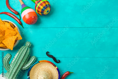 Cinco de Mayo holiday background with Mexican cactus, nachos chips, maracas and party sombrero hat. Top view, flat lay