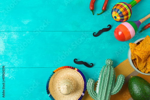 Cinco de Mayo holiday background with Mexican cactus, nachos chips, maracas and party sombrero hat. Top view, flat lay